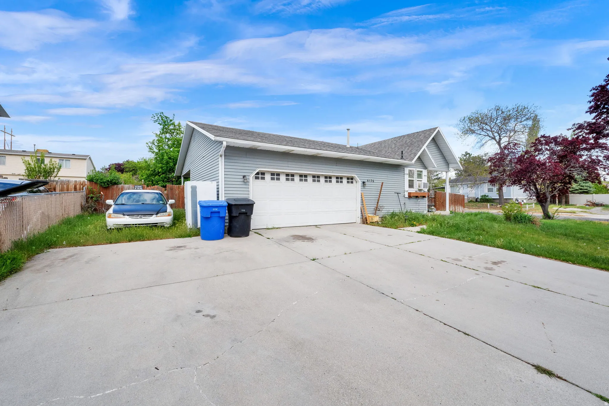 View of side of home featuring a shingled roof, driveway, and a garage