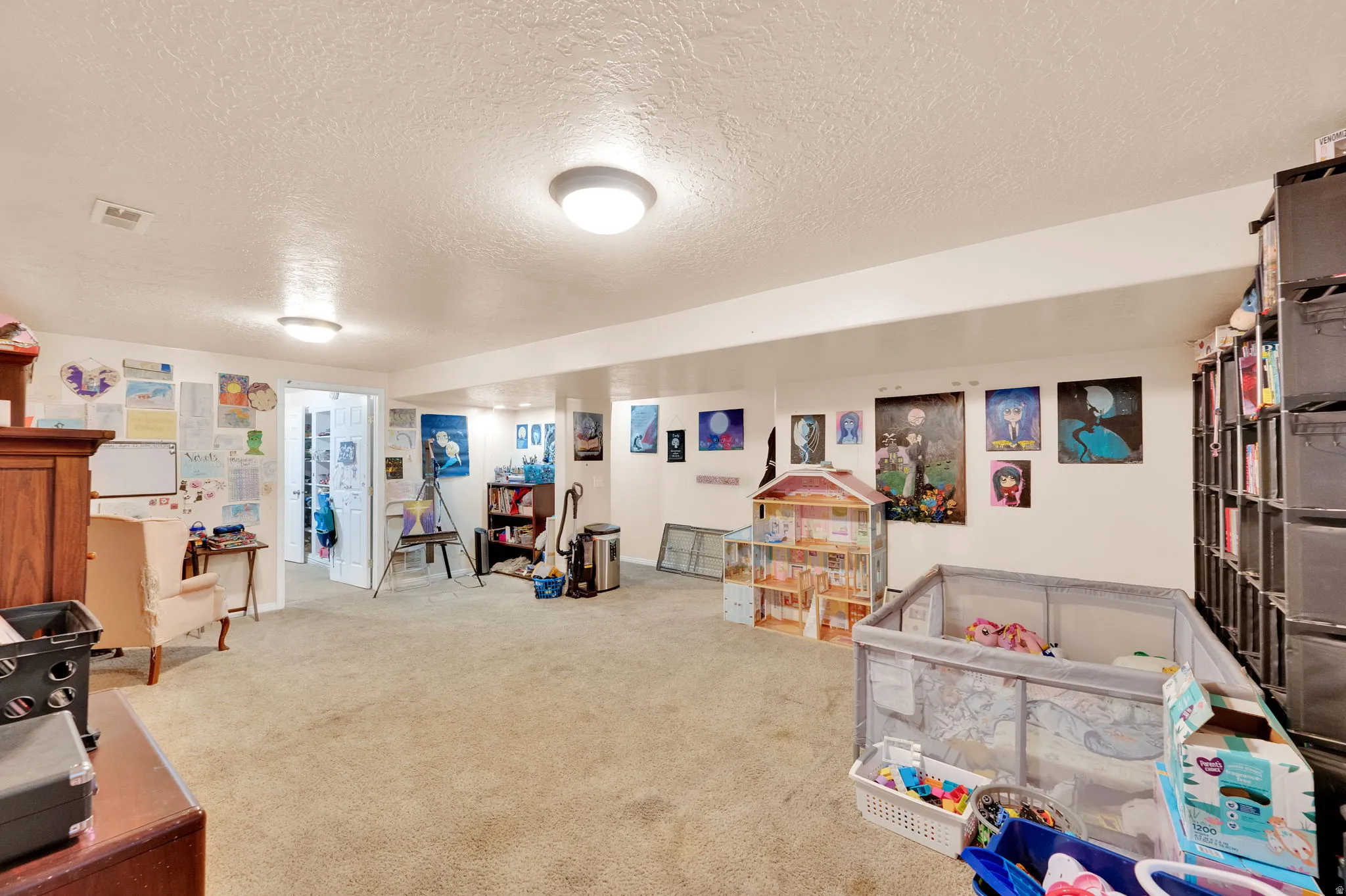 Recreation room featuring a textured ceiling and carpet floors
