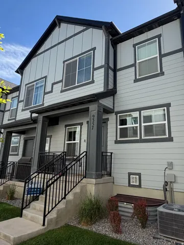 Contemporary exterior featuring light gray horizontal siding and vertical paneling, contrasted by dark trim