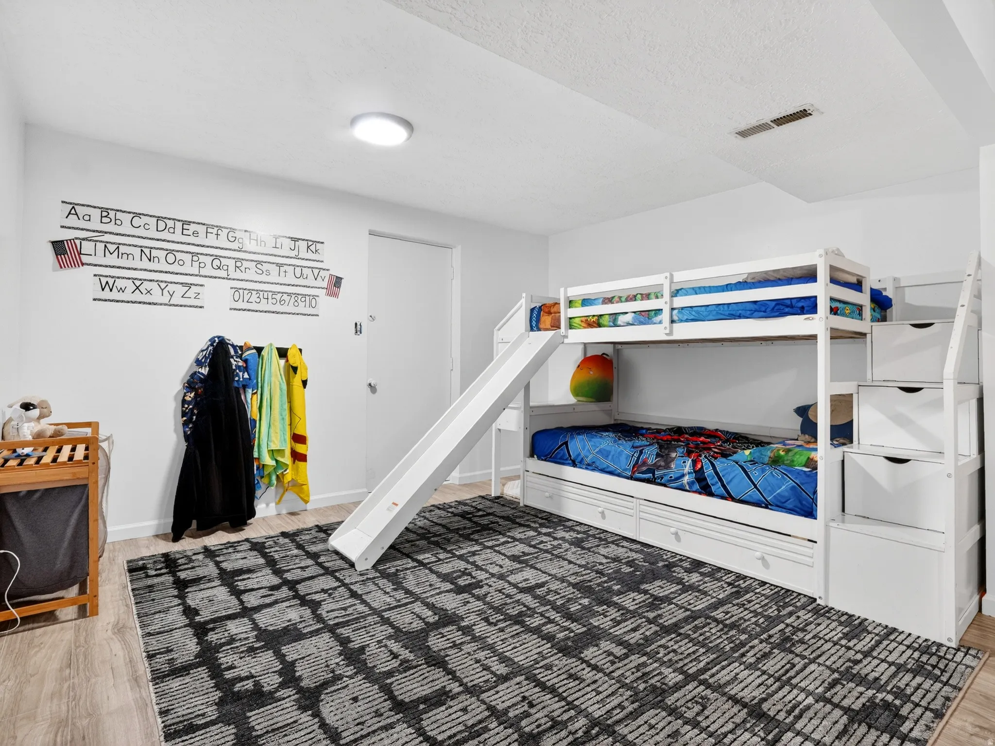 Bedroom featuring light wood finished floors and a textured ceiling