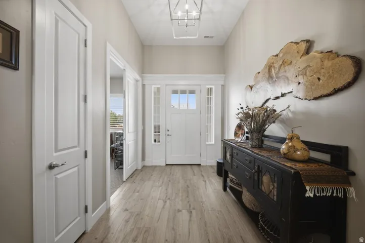 Entryway featuring light wood-style floors and a chandelier