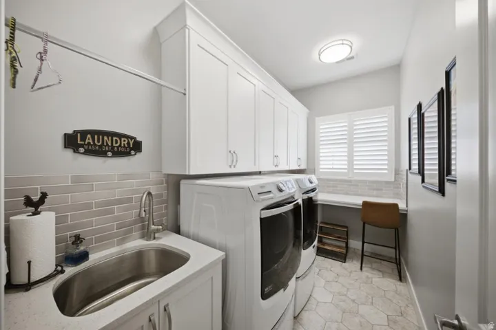 Laundry area with separate washer and dryer, cabinet space, and a wainscoted wall