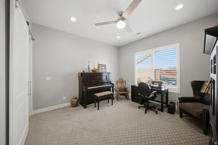 Office space with light carpet, ceiling fan, a barn door, and recessed lighting