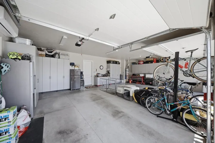 Garage with freestanding refrigerator and a mini split for heating / cooling