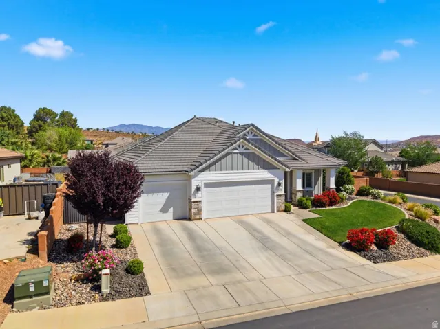 View of front of property with a garage, board and batten siding, stone siding, concrete driveway, and a mountain view