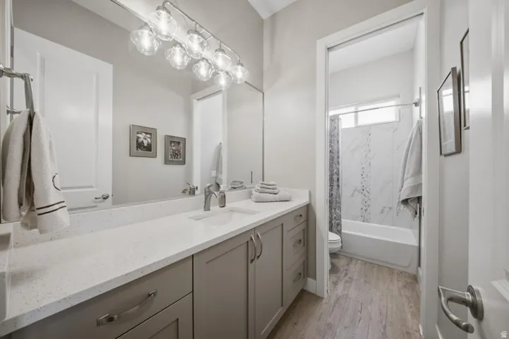 Bathroom featuring vanity,  shower combination, and light wood-style floors
