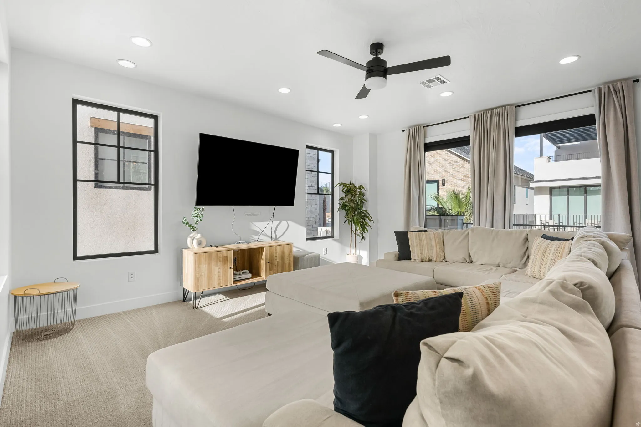 Living area with carpet flooring, plenty of natural light, a ceiling fan, and recessed lighting