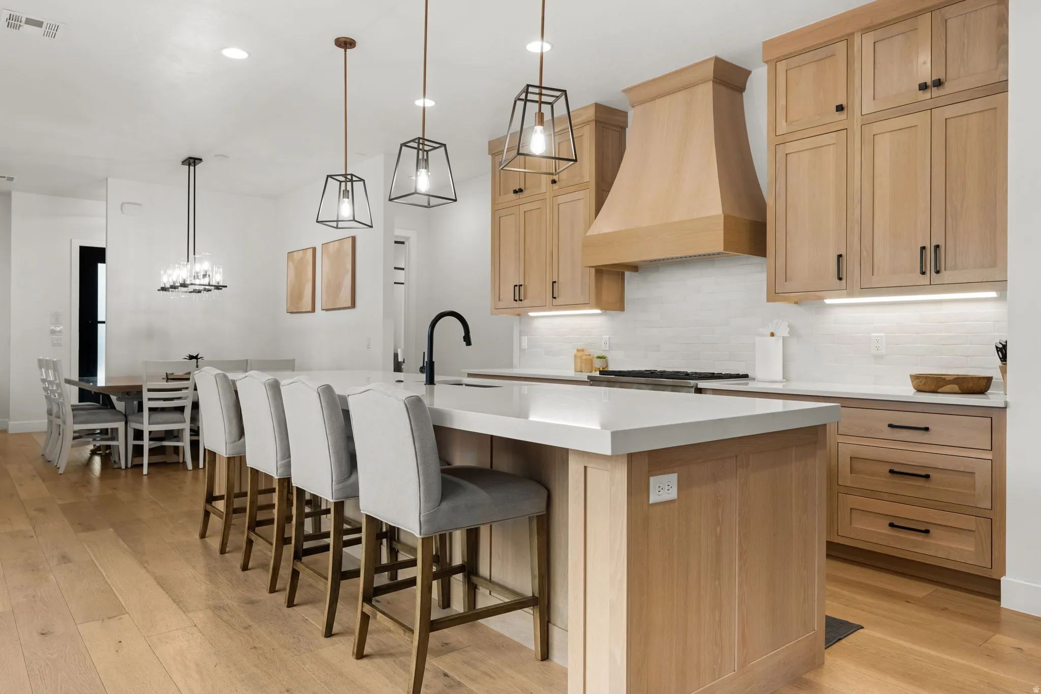 Kitchen with light wood-style floors, light wood finish cabinetry, and a kitchen bar