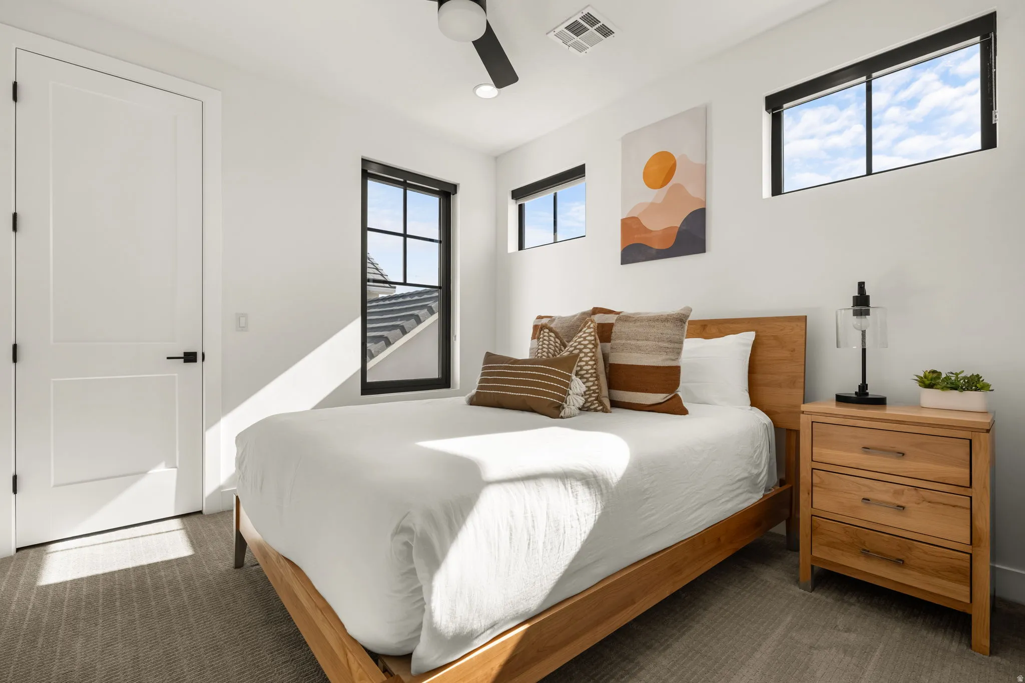Bedroom with ceiling fan and dark colored carpet