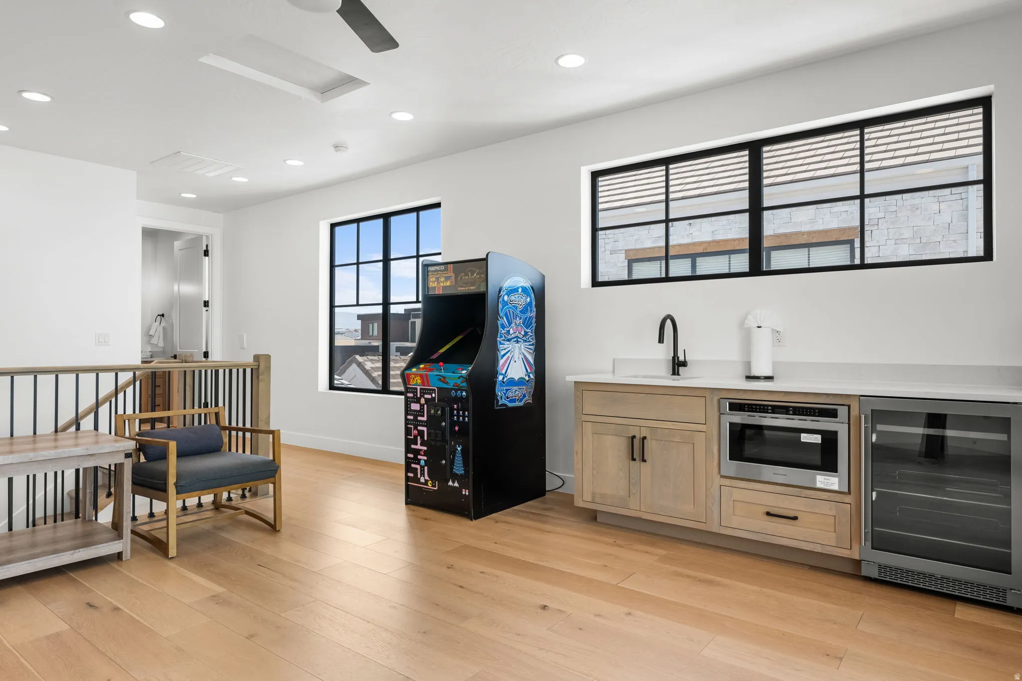 Bar area featuring light wood finish cabinets, beverage cooler, recessed lighting, and light wood-type flooring