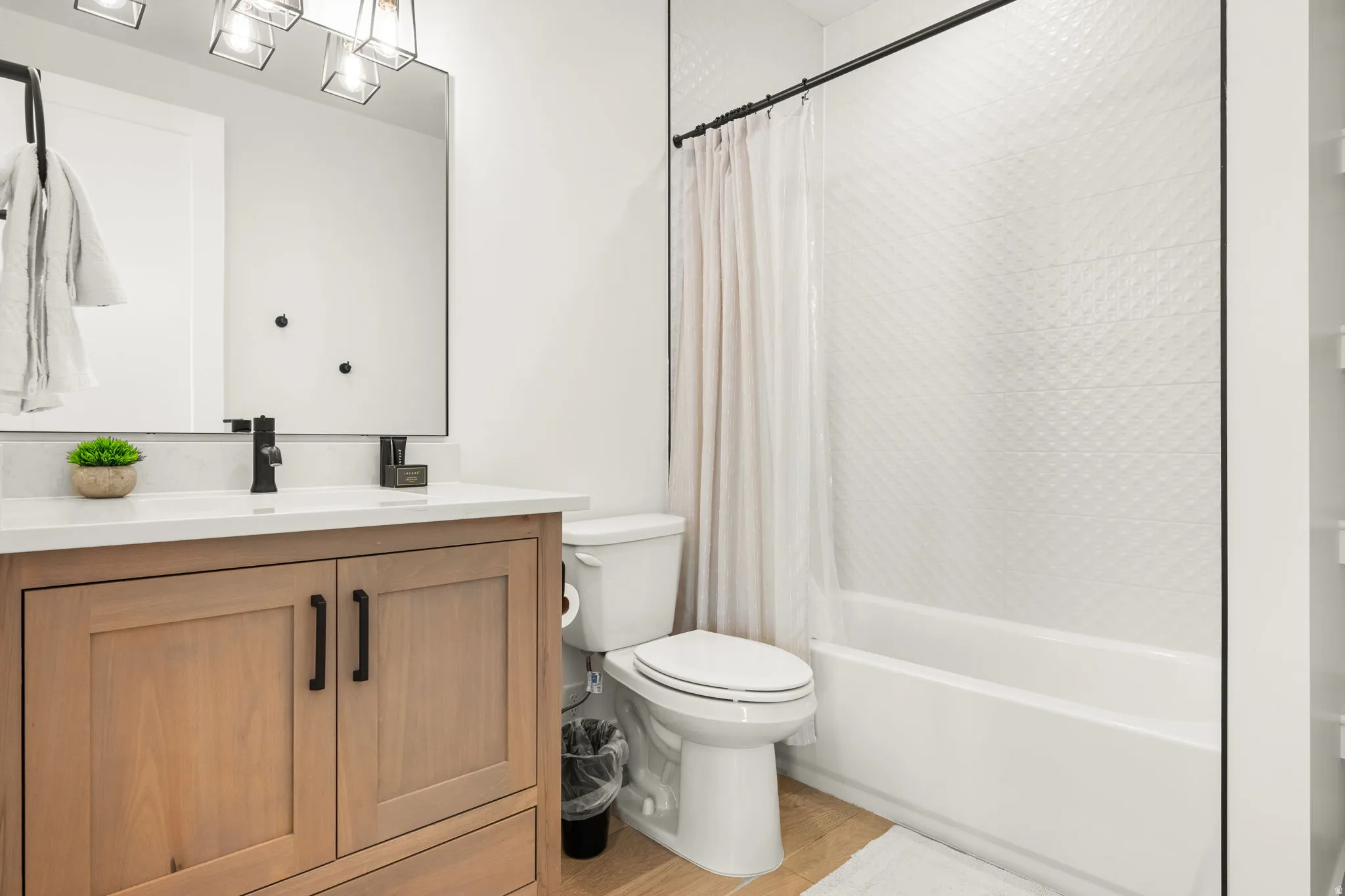 Full bath featuring vanity, shower / bath combo with shower curtain, and light wood-style flooring