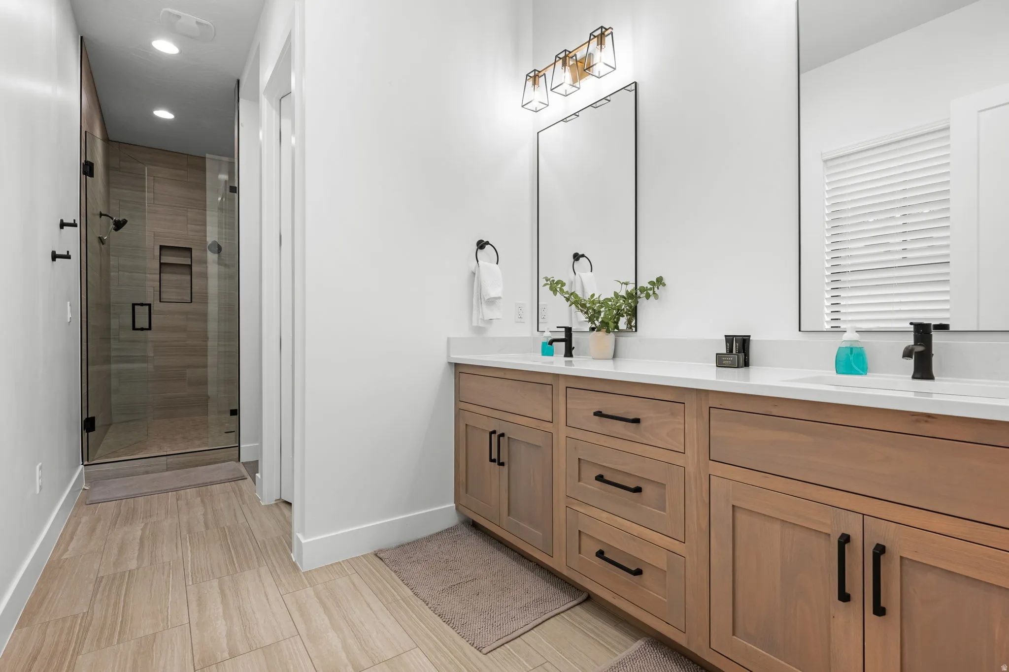 Bathroom with a shower stall, double vanity, and recessed lighting