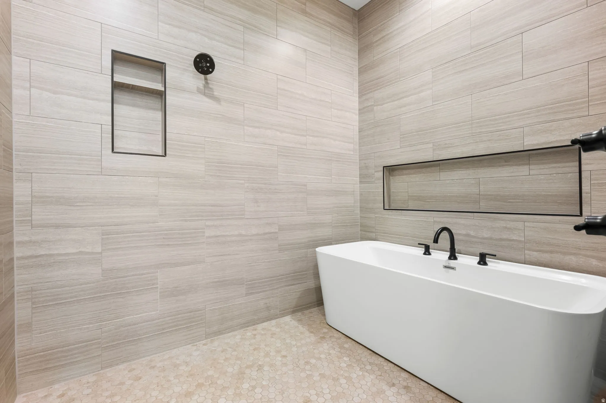 Full bath with tile walls and a soaking tub