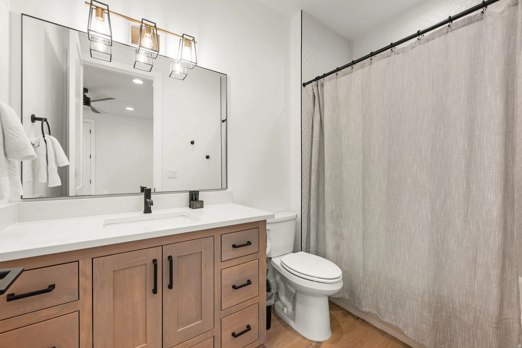 Bathroom featuring vanity, a shower with curtain, light wood-type flooring, a ceiling fan, and recessed lighting