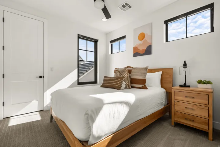 Bedroom with ceiling fan and dark colored carpet