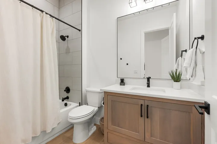 Bathroom featuring vanity, shower / bath combo, and light wood finished floors