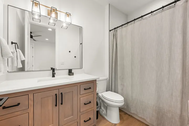 Bathroom featuring vanity, a shower with curtain, light wood-type flooring, a ceiling fan, and recessed lighting