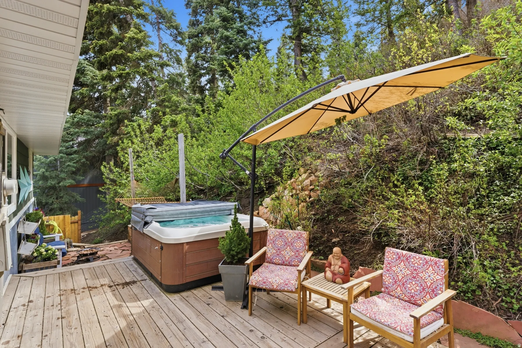 Deck with a hot tub and view of scattered trees