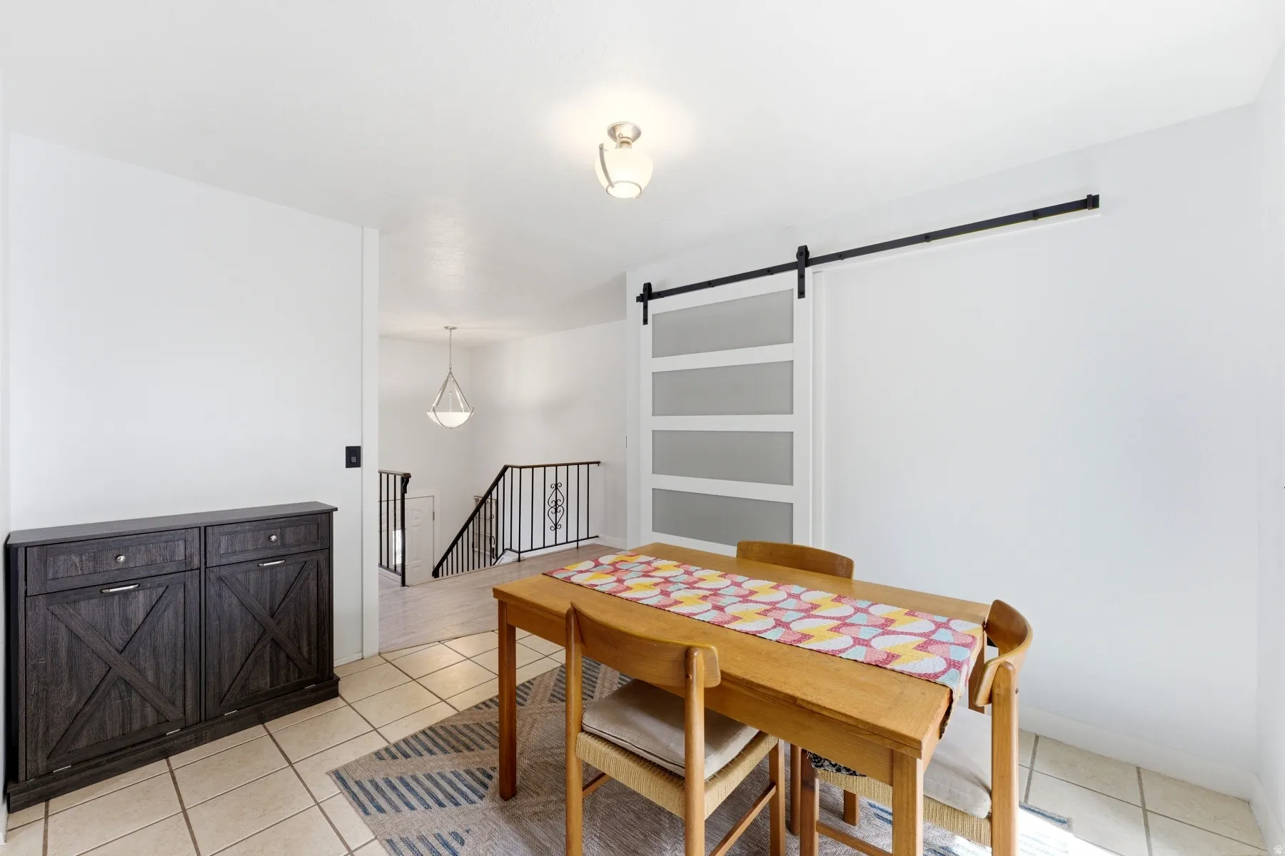 Dining room featuring a barn door and light tile patterned flooring