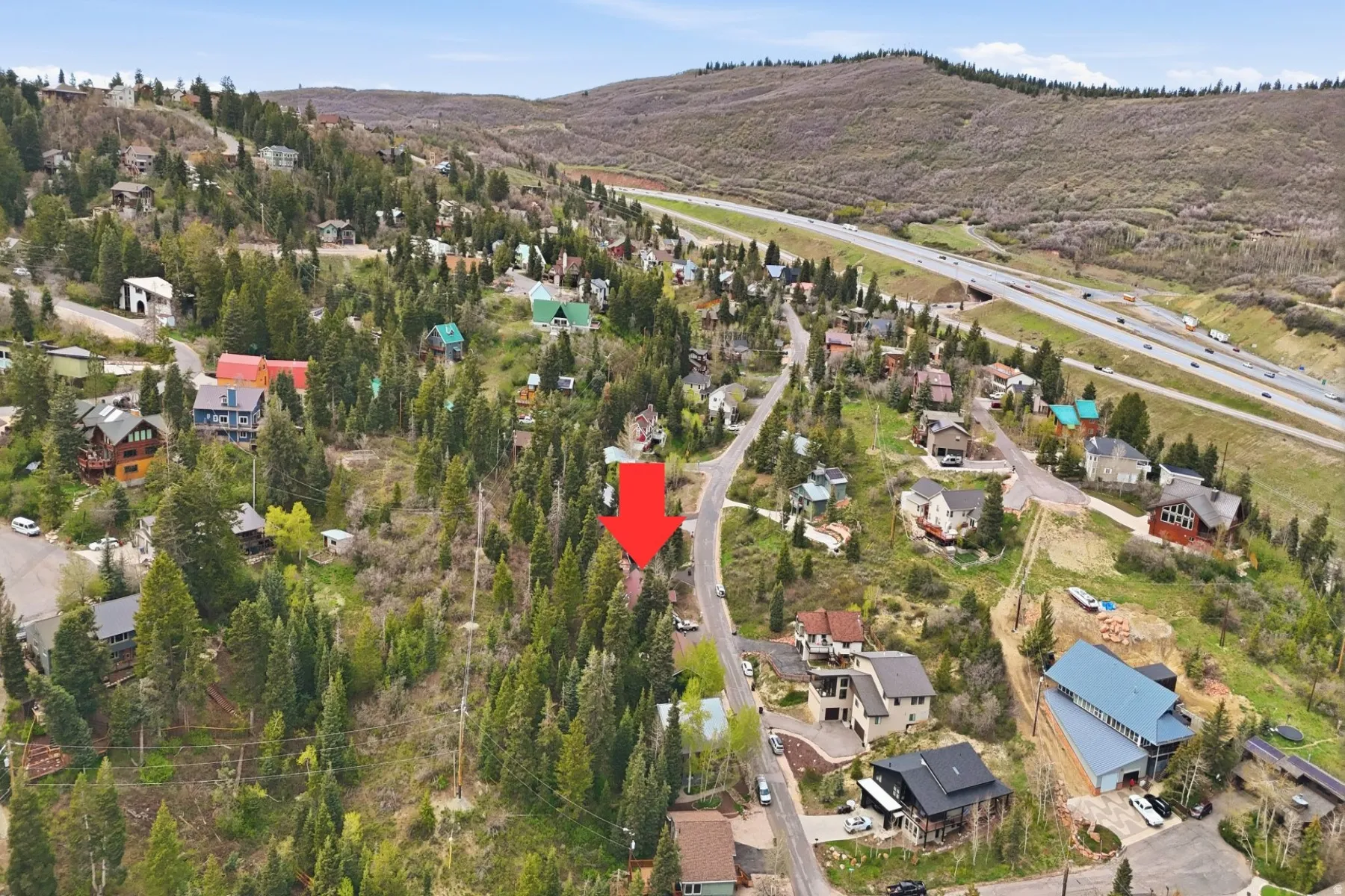 Aerial view of property's location with nearby suburban area and a mountainous background