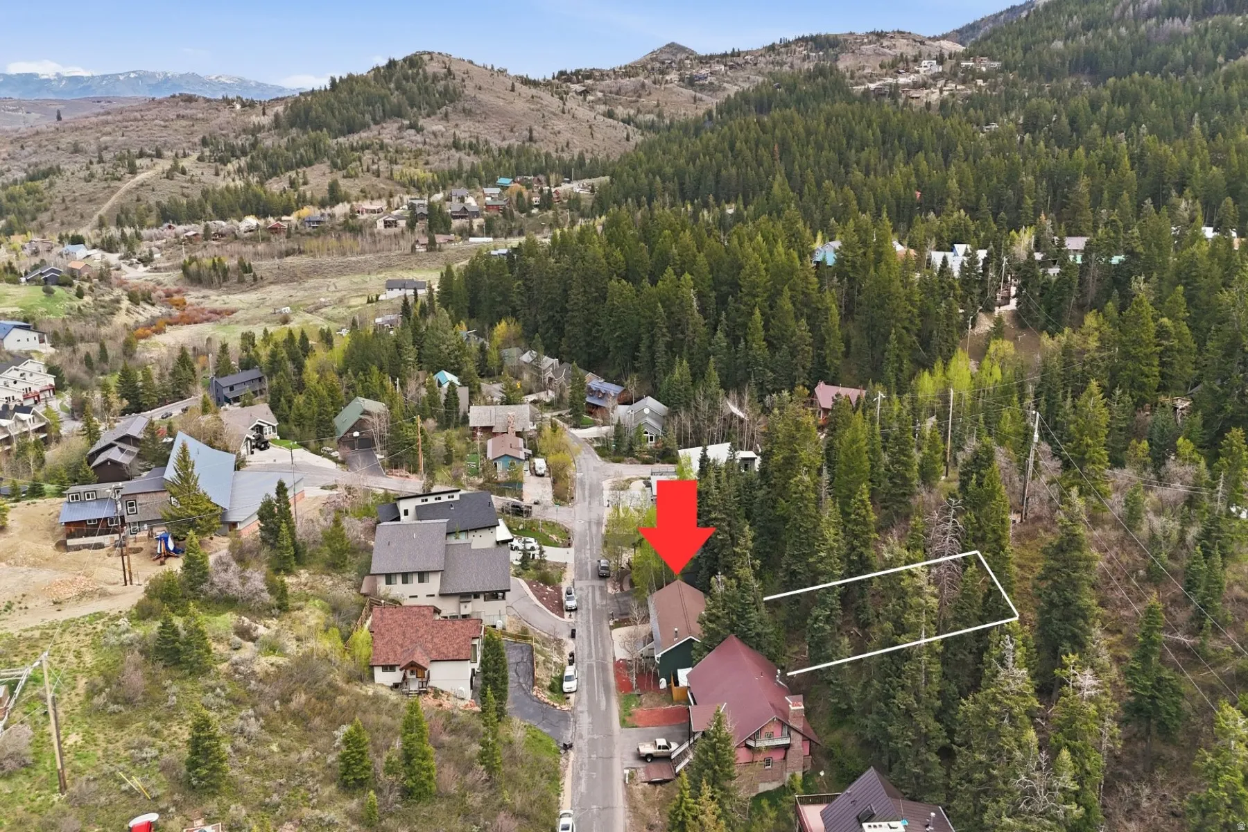 Aerial view of residential area featuring mountains and property parcel outlined