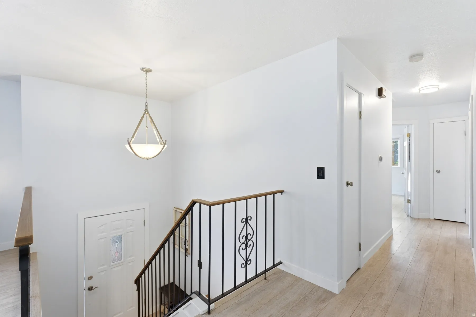 Stairs with wood finished floors and baseboards