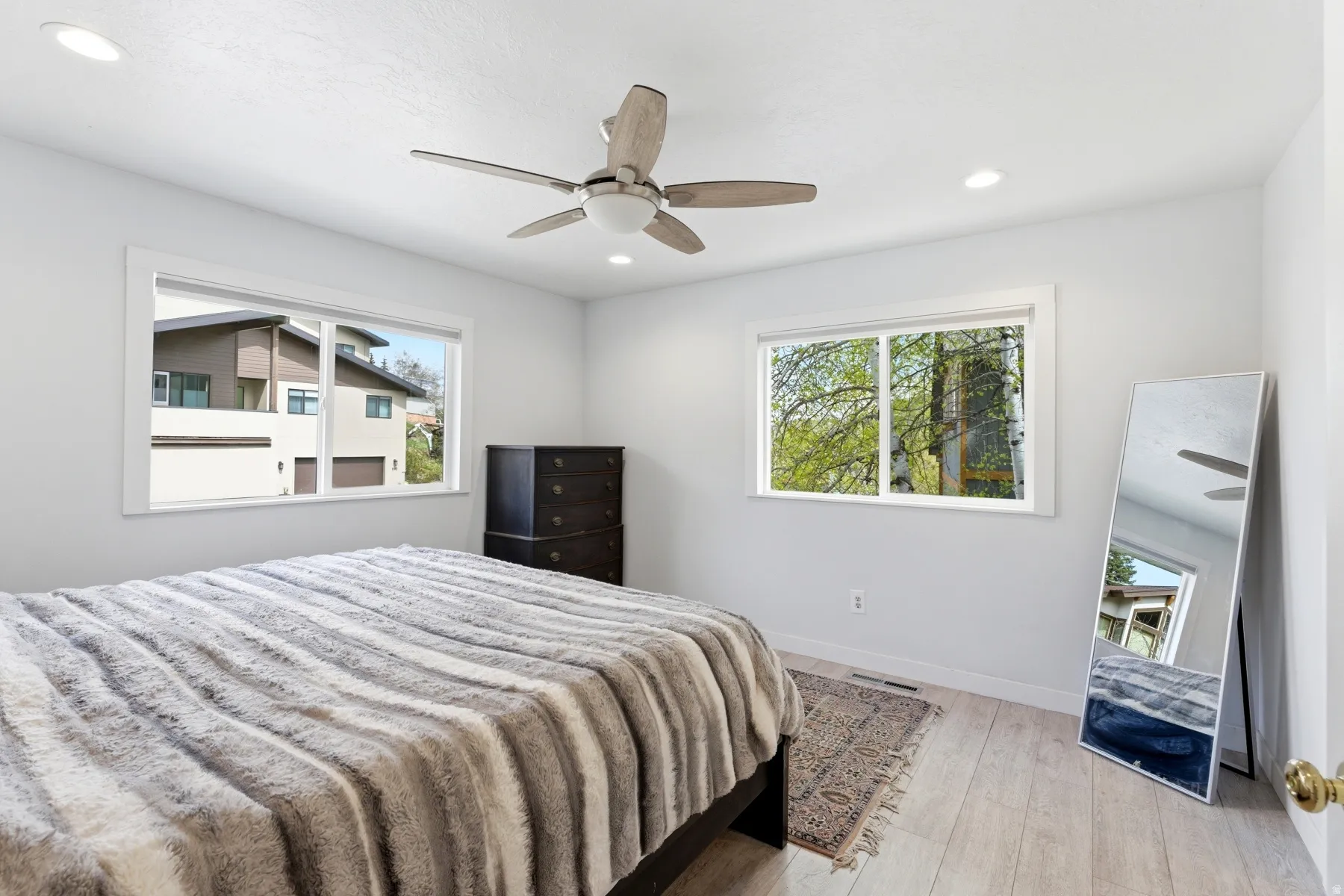 Bedroom with multiple windows, light wood-style flooring, a ceiling fan, and recessed lighting
