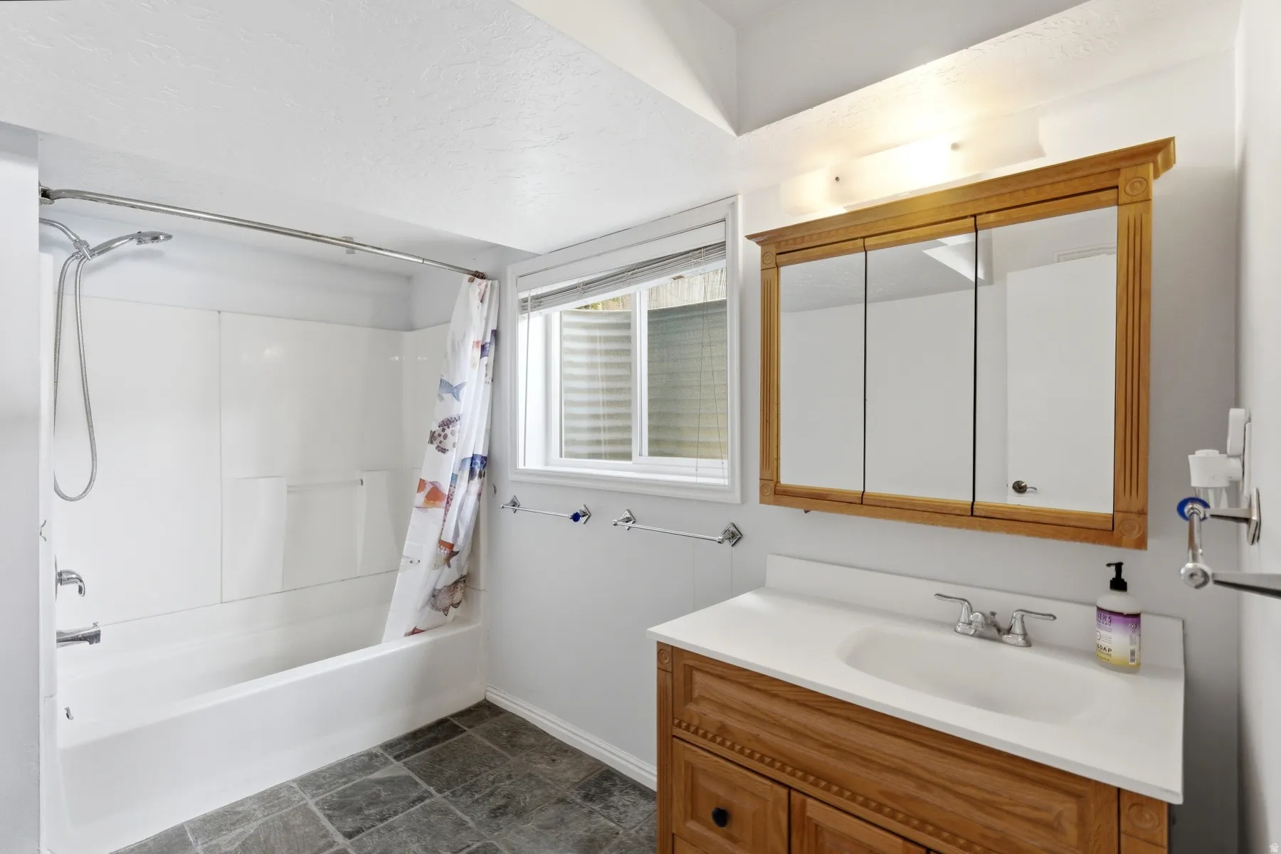 Bathroom with vanity and shower / bathtub combination with curtain
