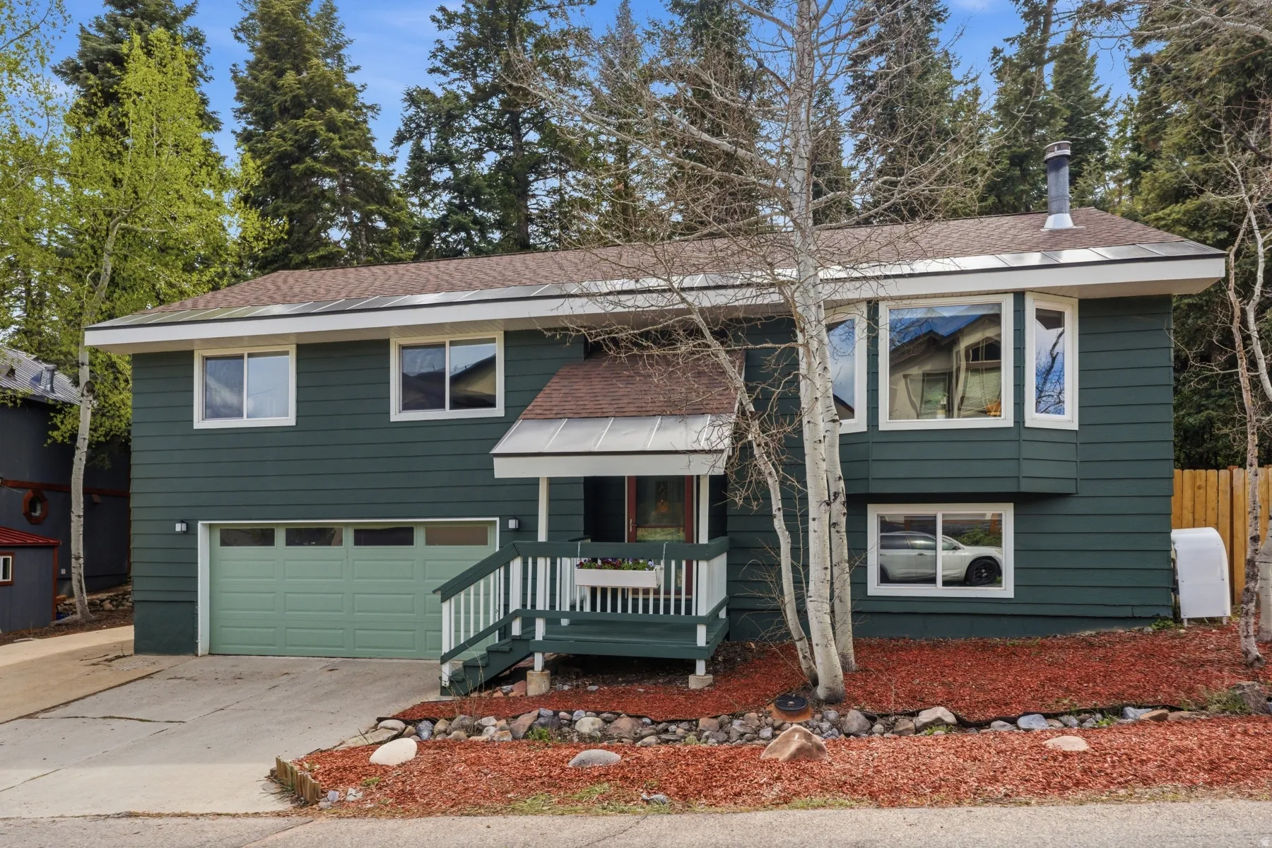 Raised ranch with a garage, roof with shingles, concrete driveway, and heating fuel