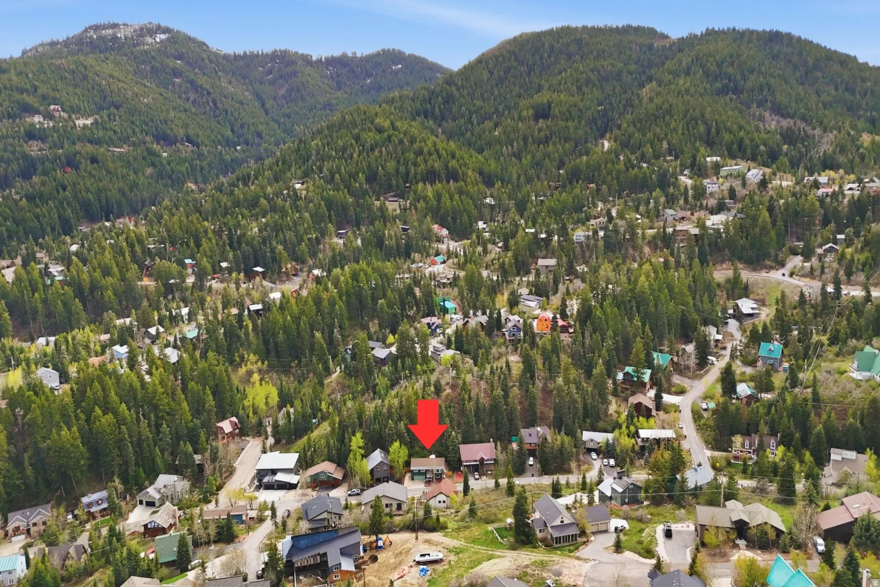 Aerial view of property and surrounding area featuring a mountain backdrop and nearby suburban area