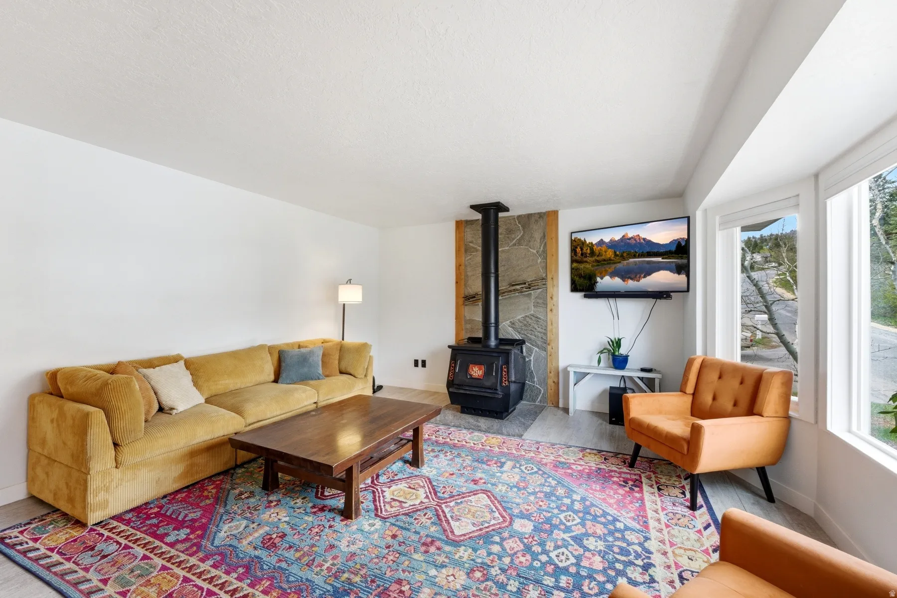 Living area with a wood stove and wood finished floors