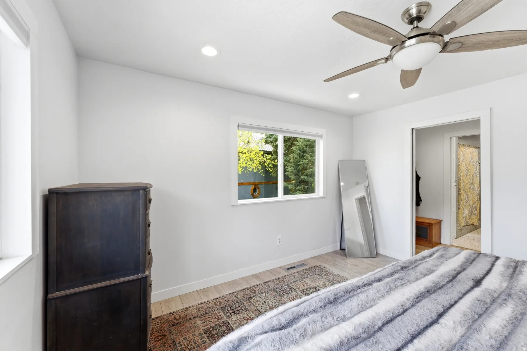Unfurnished bedroom featuring light wood finished floors, a ceiling fan, recessed lighting, and ensuite bathroom