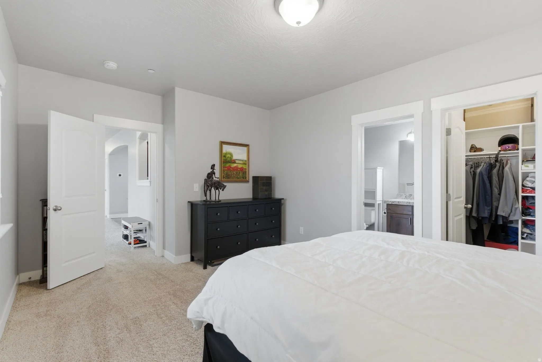 Bedroom featuring a spacious closet and light colored carpet