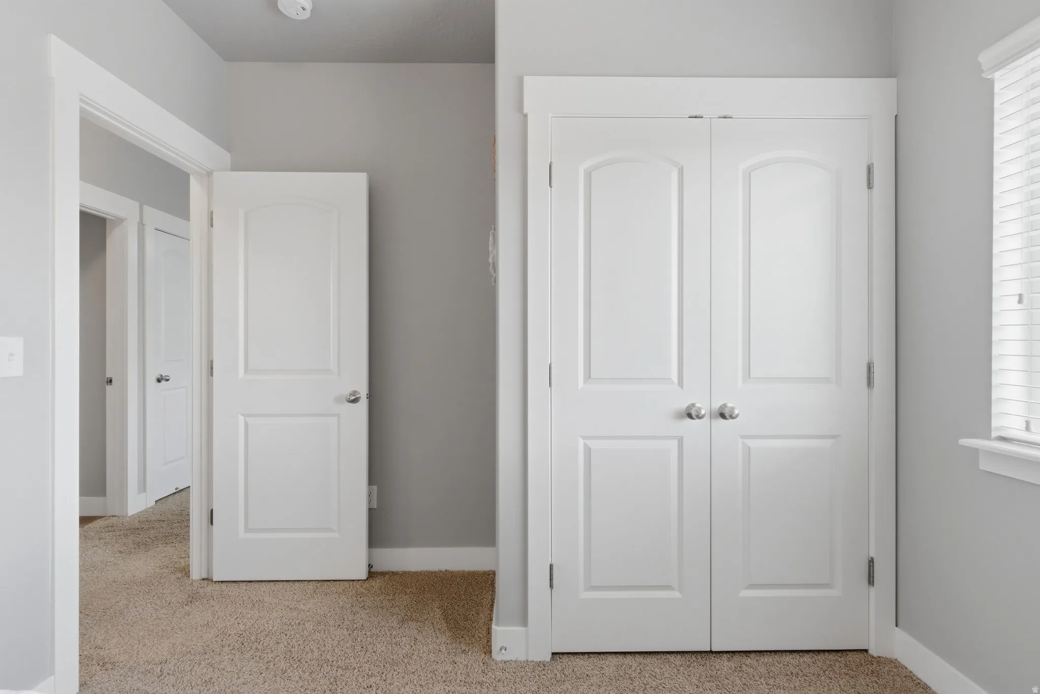 Bedroom featuring light carpet and a closet