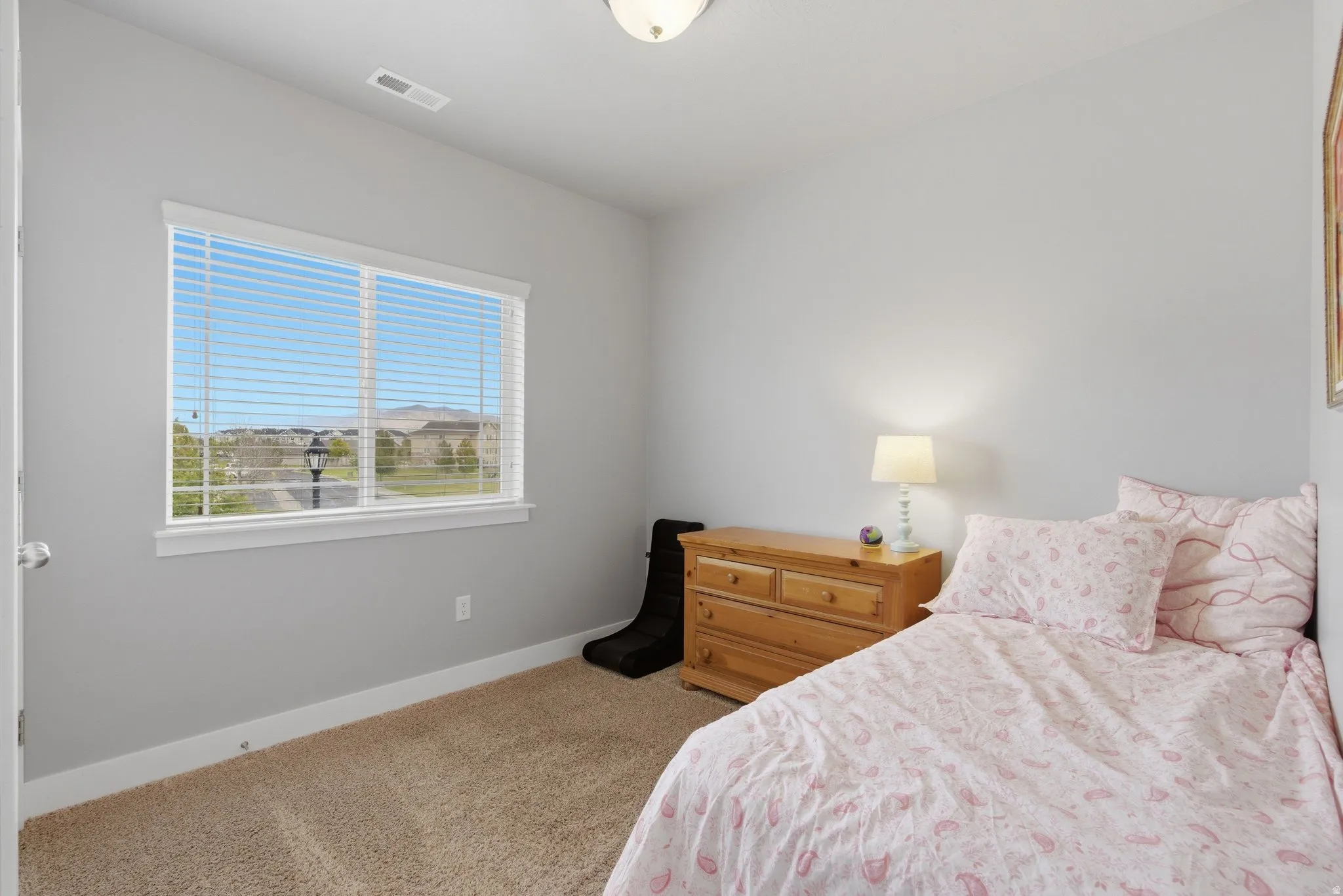 Bedroom featuring light carpet and baseboards