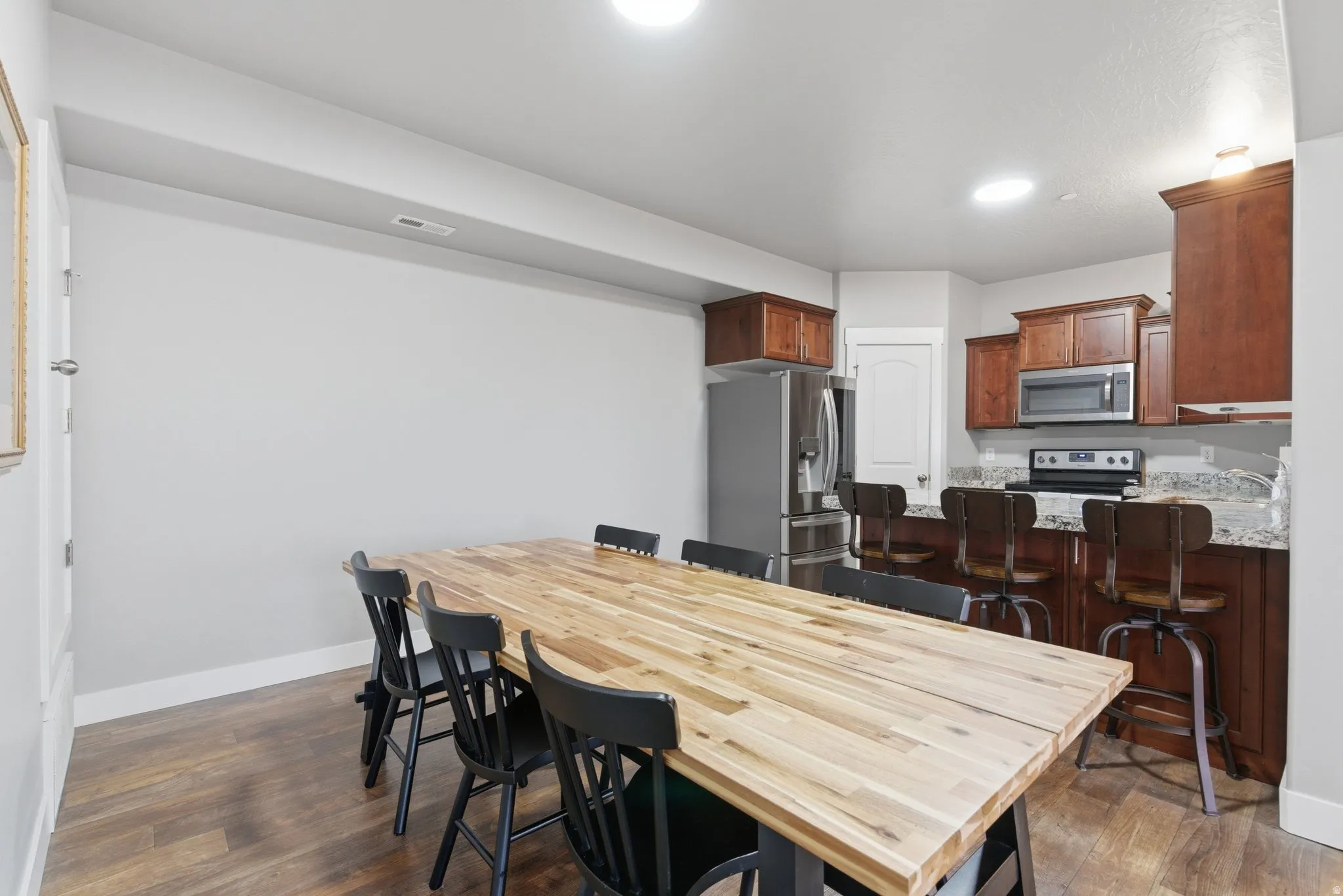 Dining room featuring dark wood finished floors and recessed lighting