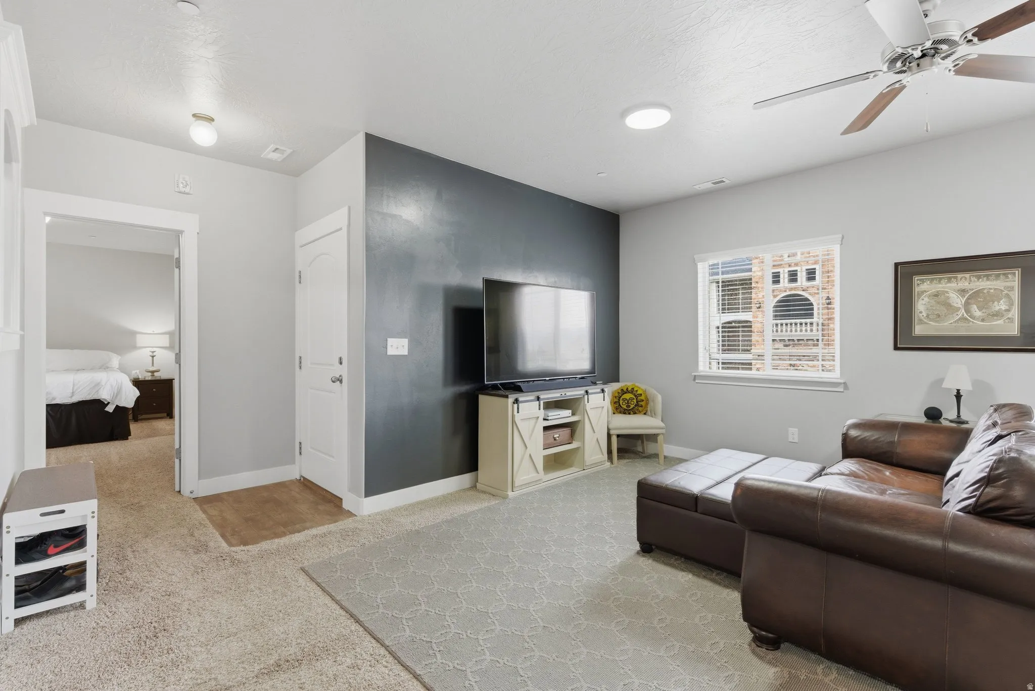 Living area featuring light colored carpet and a ceiling fan