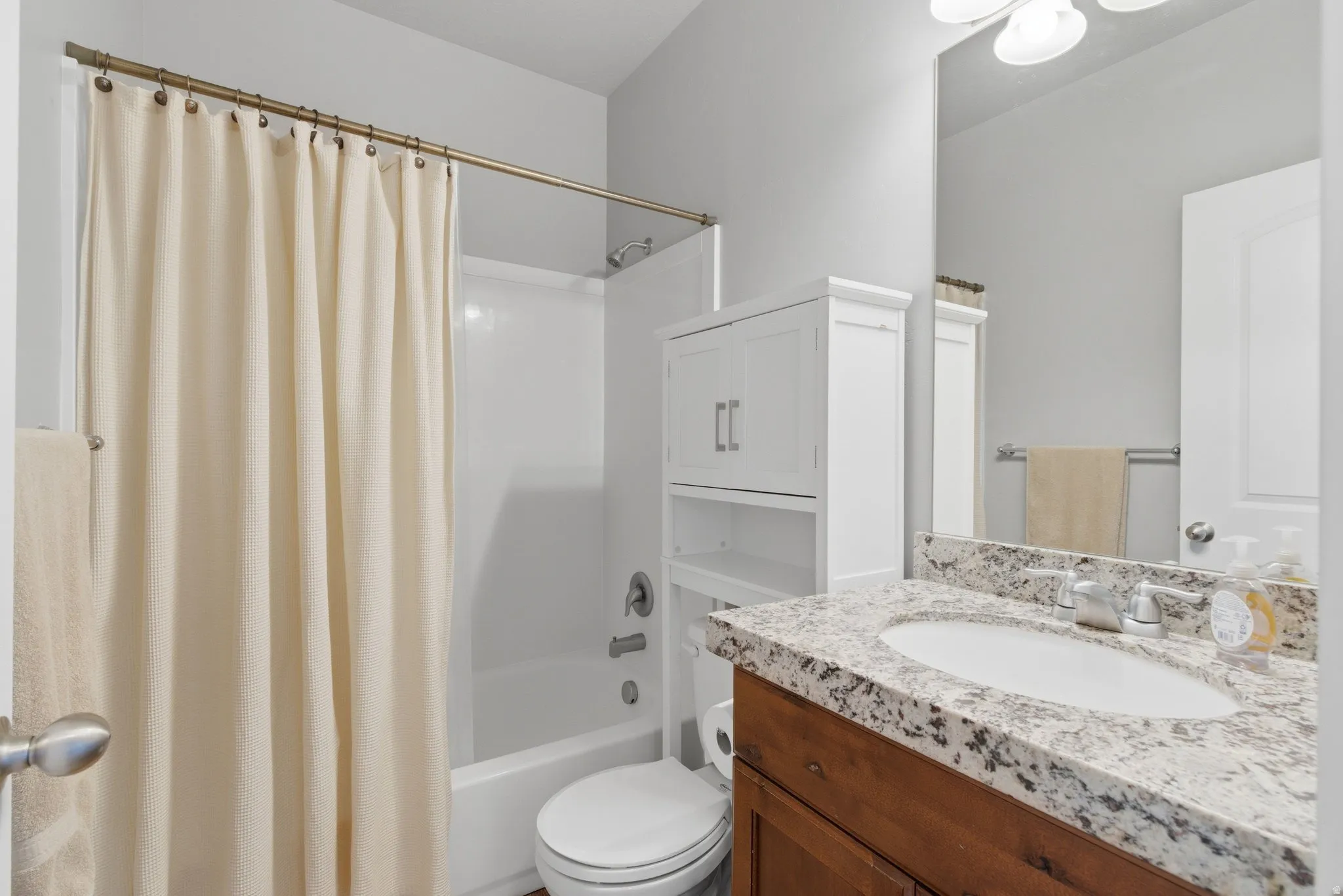 Bathroom with vanity and shower / tub combo with curtain