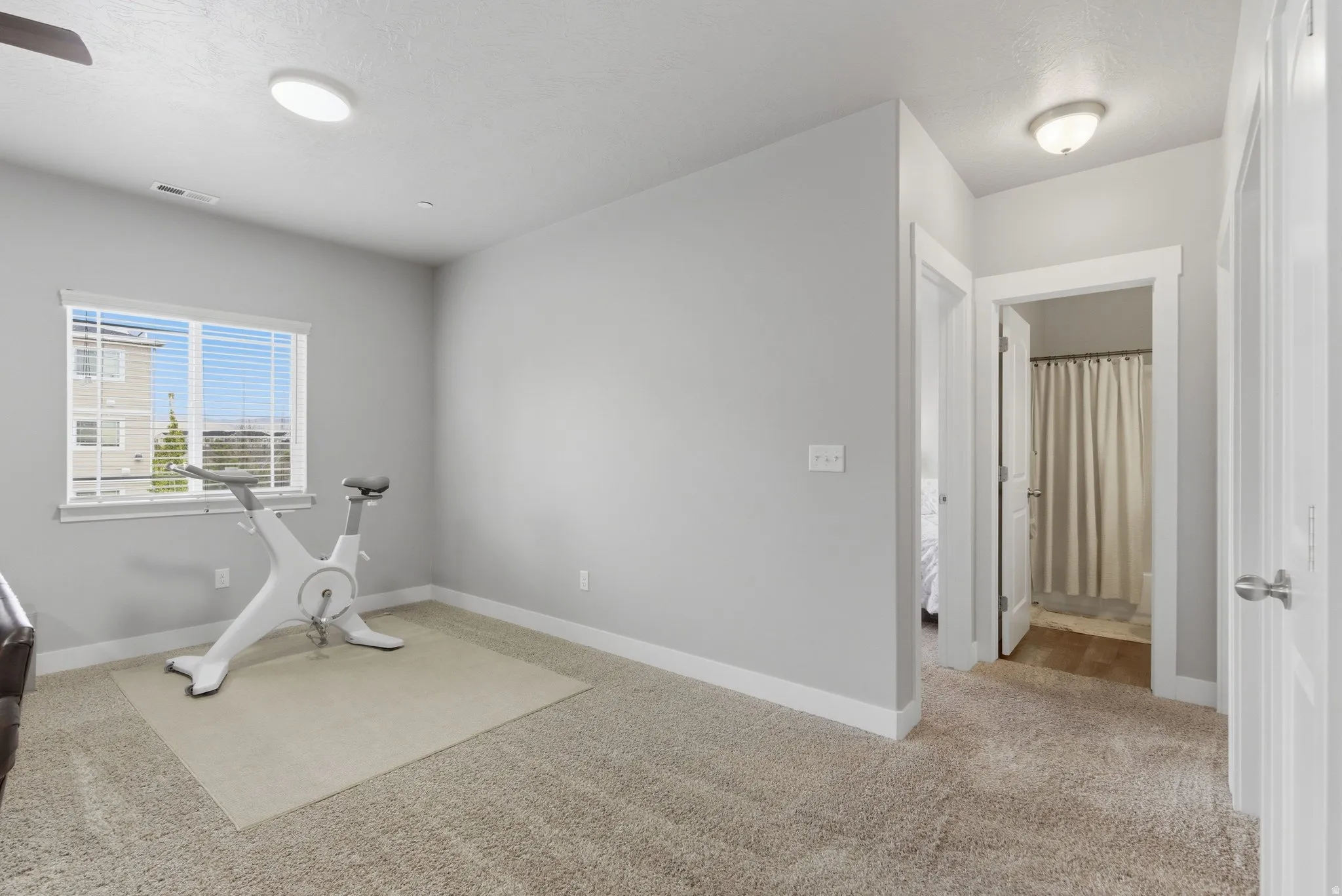 Workout area featuring light carpet and baseboards