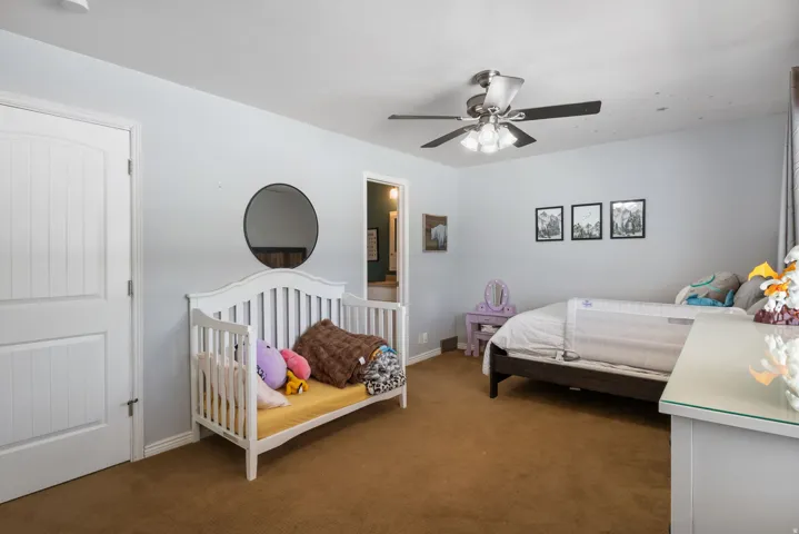 Bedroom featuring dark colored carpet and a ceiling fan