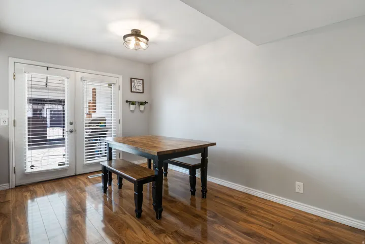 Dining area with dark wood-style floors and french doors