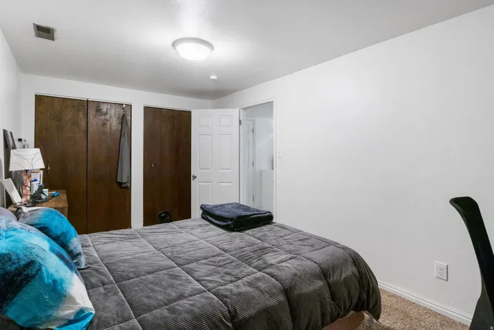 Bedroom featuring carpet and two closets