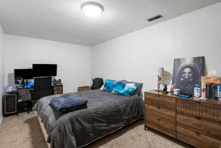 Bedroom with light carpet and a desk