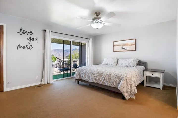 Bedroom with access to outside, carpet, ceiling fan, and a mountain view