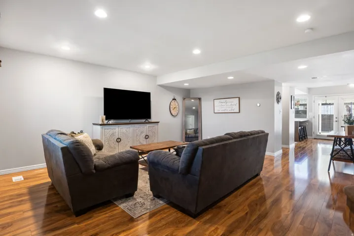 Living area with hardwood / wood-style flooring and recessed lighting