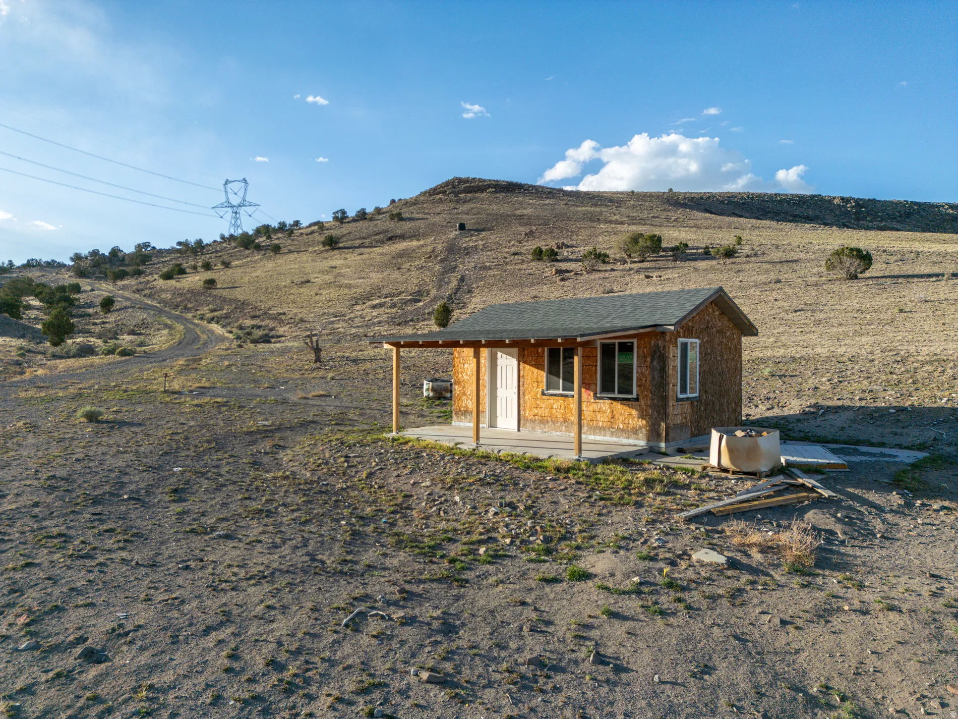 Rear view of property featuring a porch and an outdoor structure