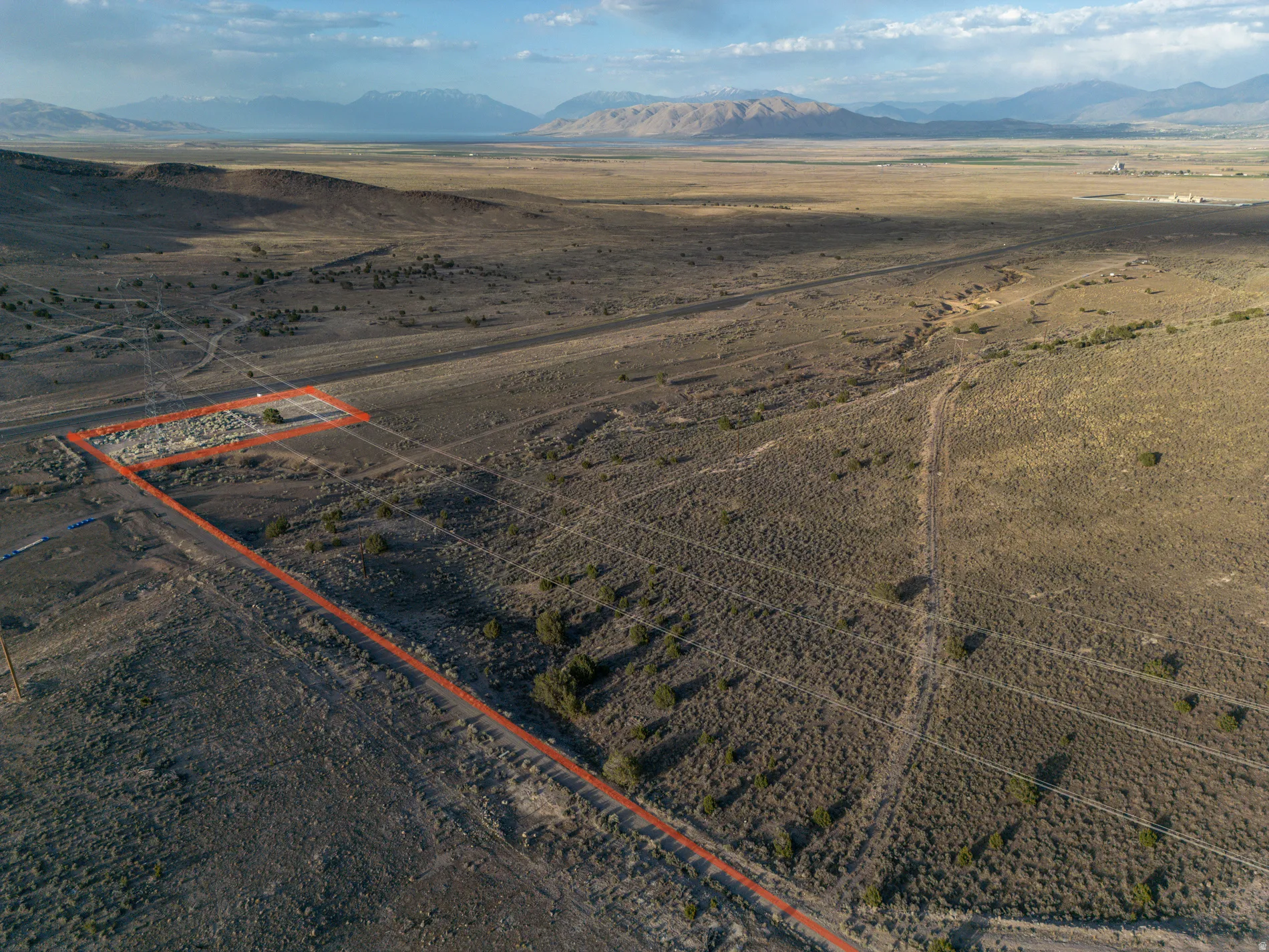 Overview of rural landscape featuring a mountain backdrop and property boundaries highlighted
