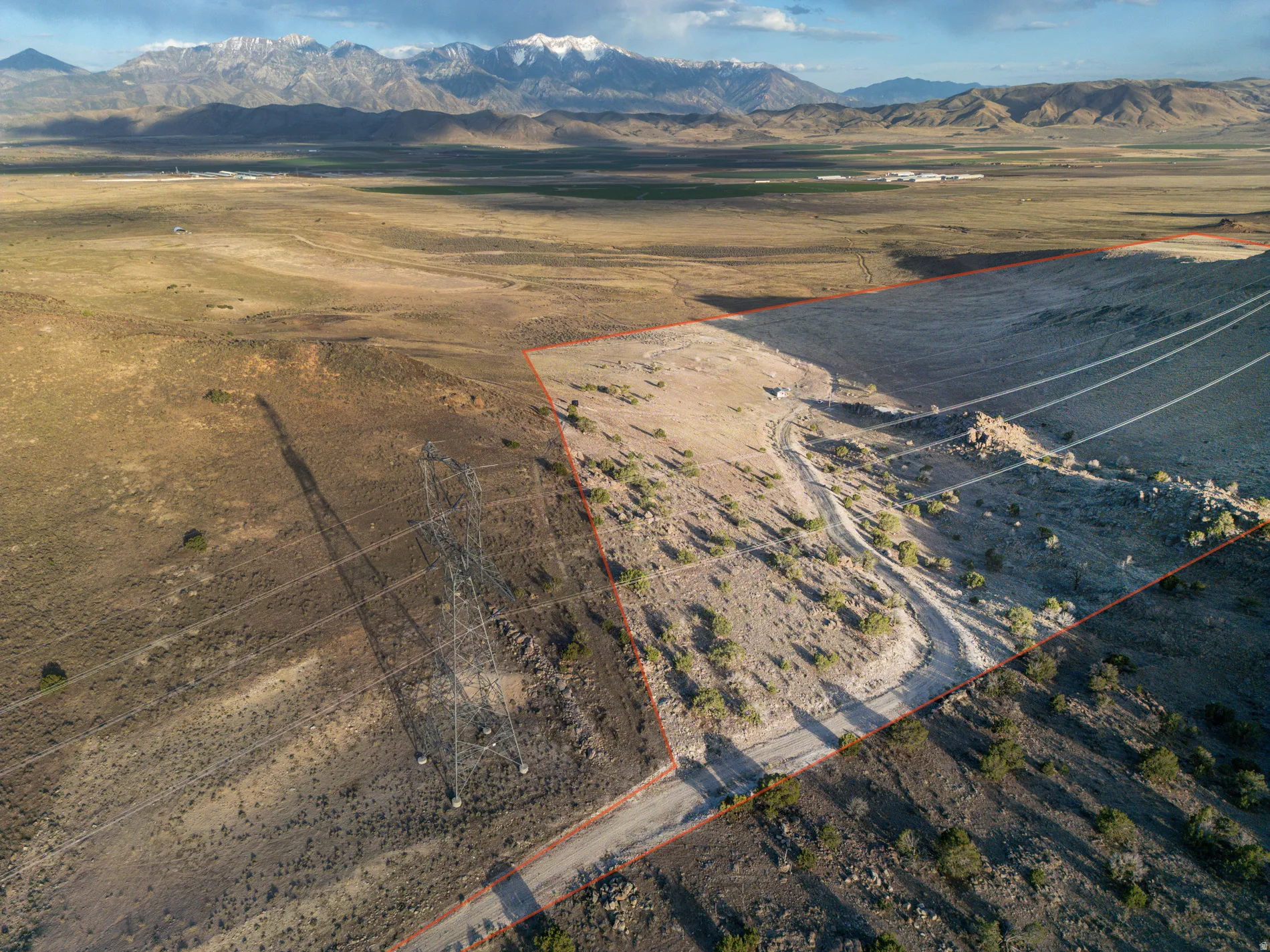 Overview of rural landscape with property boundaries highlighted and a mountain backdrop