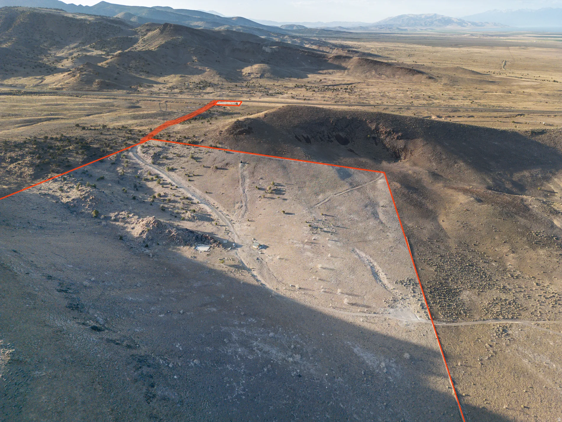 Overview of rural landscape featuring a mountainous background and property boundaries highlighted