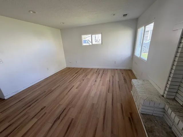Spare room featuring dark wood finished floors and a textured ceiling